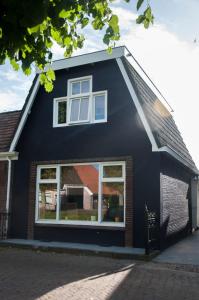 斯塔福伦Heerlijk Huis aan het IJsselmeer的一面有窗户的黑色房子