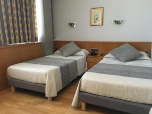 阿尔曼萨Encasa Hotel Almansa的一间卧室设有两张床和窗户。