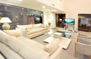 布兰卡港艾格洛斯酒店的客厅配有白色家具和电视