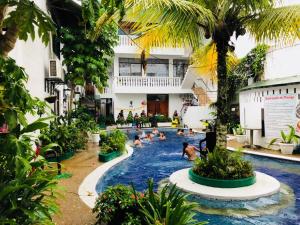 莱蒂西亚Hotel Yurupary AMAZONAS的度假村内有人和狗的游泳池