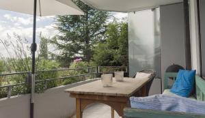 康斯坦茨Seesterne Comfort的阳台配有桌椅和遮阳伞