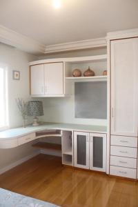 弗洛里亚诺波利斯FamilyHome的白色的厨房配有白色的橱柜和桌子