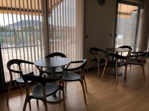 巴利亚多利德里奥霍特加酒店的一组桌椅,位于一个窗户的房间