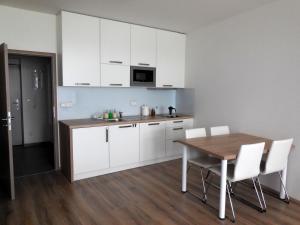 布尔诺Apartment Potter的厨房配有木桌和白色橱柜。