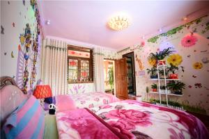丽江汤姆家客栈的卧室配有一张墙上鲜花的床