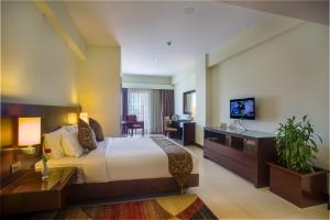 巴里沙尔Hotel Grand Park Barishal的酒店客房设有一张大床和一张书桌。
