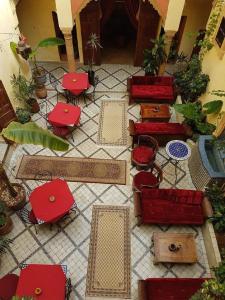 塞拉马里尼娜里亚德旅馆的一间设有红色椅子和桌子的房间,并种植了植物