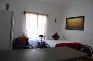 吕德里茨Villelodge Accommodation的一间卧室配有一张床、一张桌子和一个窗户。