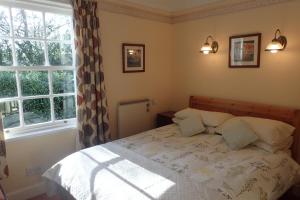 AppinLaich Cottage的一间卧室配有带两个枕头的床和窗户