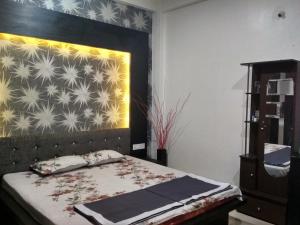 印多尔Ashta Lakshmi Tourist Home Stay的一间卧室配有一张带床头板和墙壁的床
