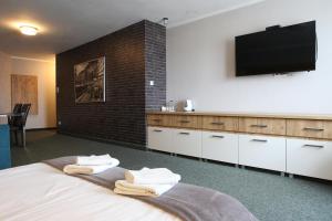 波兹南阳光酒店的卧室配有一张壁挂式平面电视的床。