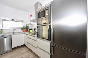 阿马多雷斯Beyond Amadores C&H Suite Nº4的厨房配有不锈钢冰箱和微波炉。