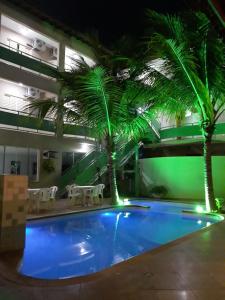 巴雷图斯Proença Hotel的一座游泳池,两棵棕榈树位于一座建筑中