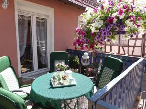 RambergFerienhaus Agnes的鲜花阳台的绿色桌椅