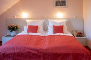 埃尔维特Hotel zur Therme的一间卧室配有一张红色大床和两个红色枕头