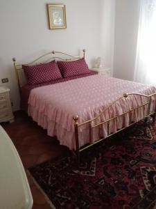 拉泰里纳Villa Marina Big的一间卧室配有一张带粉红色棉被和地毯的床