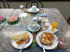 ArapongasLodi Express Hotel的餐桌,早餐包括烤面包、咖啡和橙汁