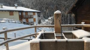 BedolloIl Cardo Trentino的房屋旁的雪覆盖的栅栏