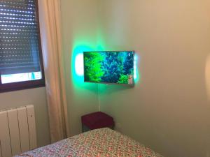 安锡The One Suite Annecy的卧室配有壁挂式平面电视。