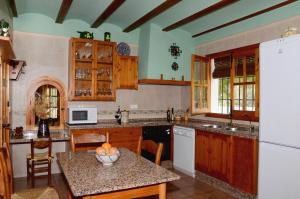 普里埃格·德·科尔多巴Casa de la Higuera的厨房配有木制橱柜和桌子