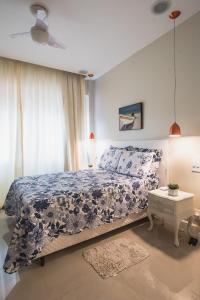里约热内卢Copacabana, conforto e localização的一间卧室配有一张带蓝色和白色床单的床。