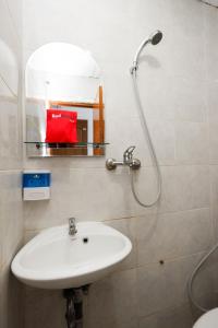 三宝垄RedDoorz Near Kota Lama Semarang的浴室配有盥洗盆和带镜子的淋浴