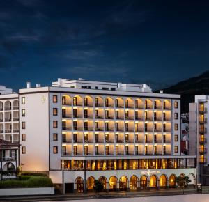 蓬塔德尔加达大西洋亚速尔格兰德酒店的一座白色的大建筑,灯火通明