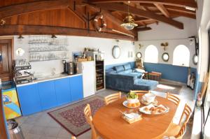 阿尔本加Residence Villa Miky的厨房以及带木桌和椅子的客厅。