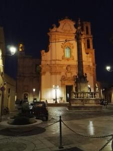普雷西切Casa Lulù的一座大型建筑,在晚上前方有一个喷泉