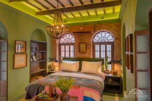 加尔各答Calcutta Bungalow的一间设有床铺的卧室,位于带窗户的房间内