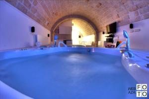 莫诺波利Suite Stone Luxury的一个带拱门的房间,有一个大型蓝色浴缸