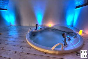 莫诺波利Suite Stone Luxury的蓝色灯的客房内的浴缸