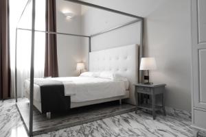 热那亚Hotel De Ville的一间卧室配有一张天蓬床和一张带台灯的桌子
