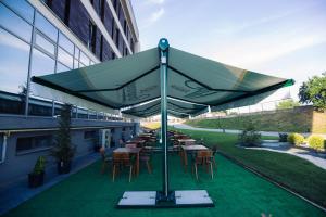 阿尔巴尤利亚马里斯酒店的一组桌子和椅子,放在一个大伞下