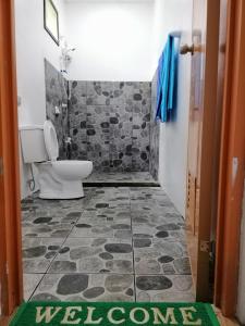 安达安德倪多特花园度假村的浴室配有卫生间和地板上的迎宾垫。