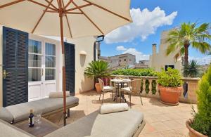 马略卡岛帕尔马圣洛伦索酒店 - 仅限成人的庭院配有遮阳伞和桌椅。