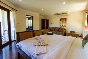 苏林海滩Surin Springs Villa by Alexanders的卧室配有白色的床和毛巾