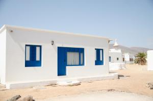 塞博河畔卡莱塔Apartamentos El Marinero - Caletilla的沙漠中带蓝色门的白色房子