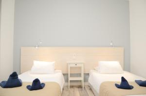 塞博河畔卡莱塔Apartamentos El Marinero - Iglesia的客房内的两张床和蓝色枕头
