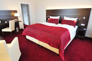 杜伊斯堡日恩盖特恩酒店的酒店客房设有一张带红色毯子的大床