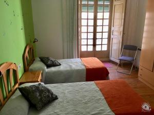 锡古恩萨Casa Tere的客房设有两张床、一把椅子和窗户。