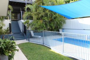 库克敦Gecko Guest House的一座带游泳池的房屋前方的蓝色围栏