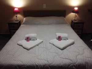 普尔马马尔卡Hospedaje Doña Velia的一间卧室配有带毛巾和杯子的床