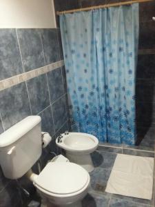 普尔马马尔卡Hospedaje Doña Velia的浴室设有卫生间和蓝色的浴帘。