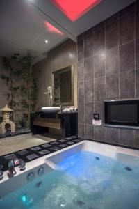 龙潭一加一汽车旅馆的一间带电视和水槽的浴缸的浴室