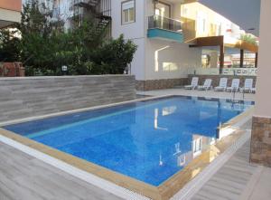 阿拉尼亚Cozy apartment Centr Alanya的一座大蓝色游泳池,位于房子前
