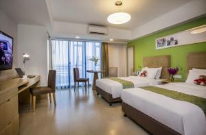 武汉武汉馨乐庭沌口公寓酒店的酒店客房设有两张床、一张桌子和一台电视。