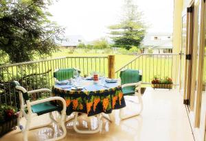 凯里凯里The Carriage House-Bay of Islands的阳台配有桌子和四把椅子,