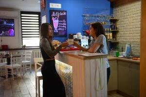 波尔塔瓦DREAM Hostel Poltava的两名妇女站在酒吧的柜台上