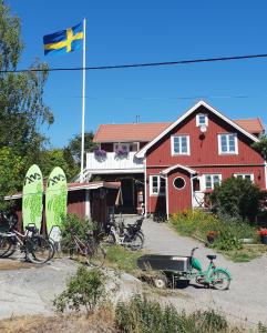 MöjaSTF Möja Vandrarhem的红房子前面悬挂着旗帜,上面有自行车